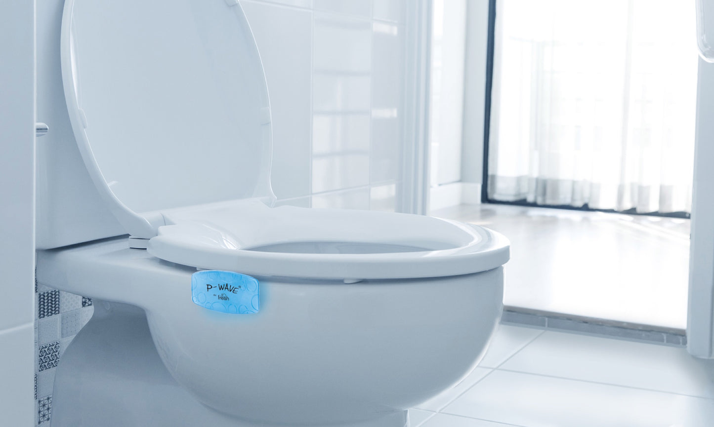 A blue Ocean Mist fragranced Bowl Clip in use on the outside of a toilet rim, under the lower seat
